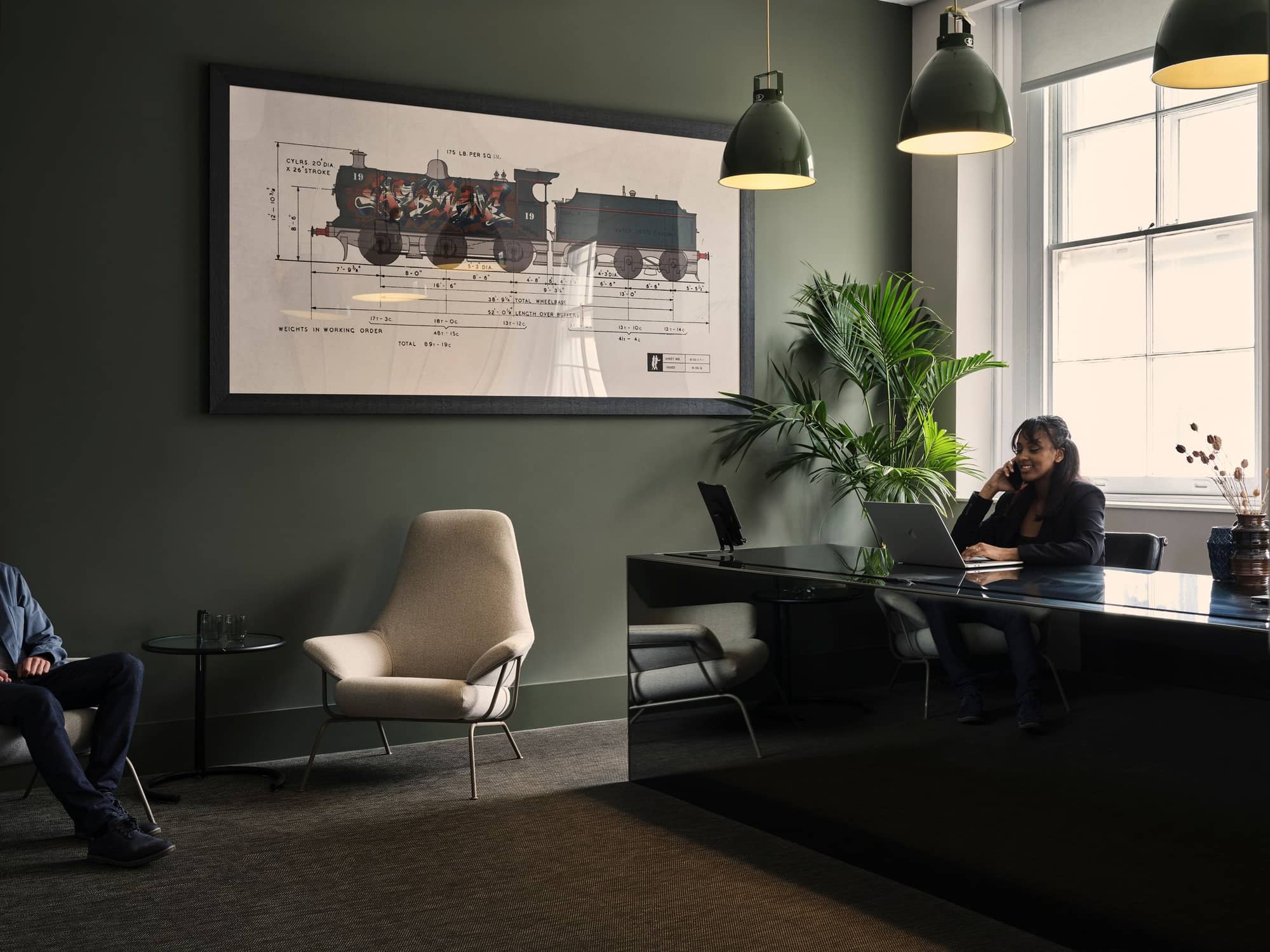 Woman talking on the phone at a big desk in a modern workspace at 19 Eastbourne Terrace.