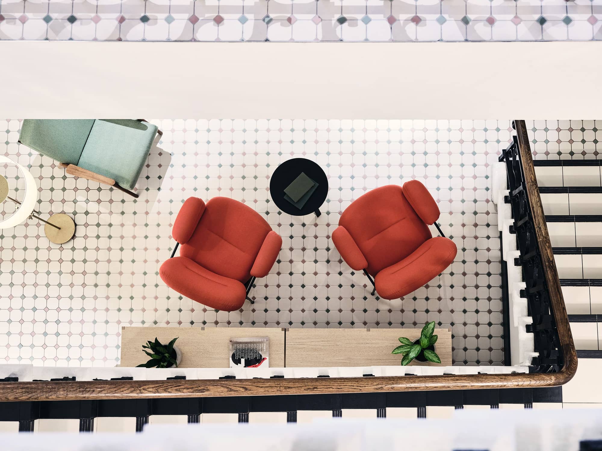 View of two red armchairs, coffee table and plants from above.