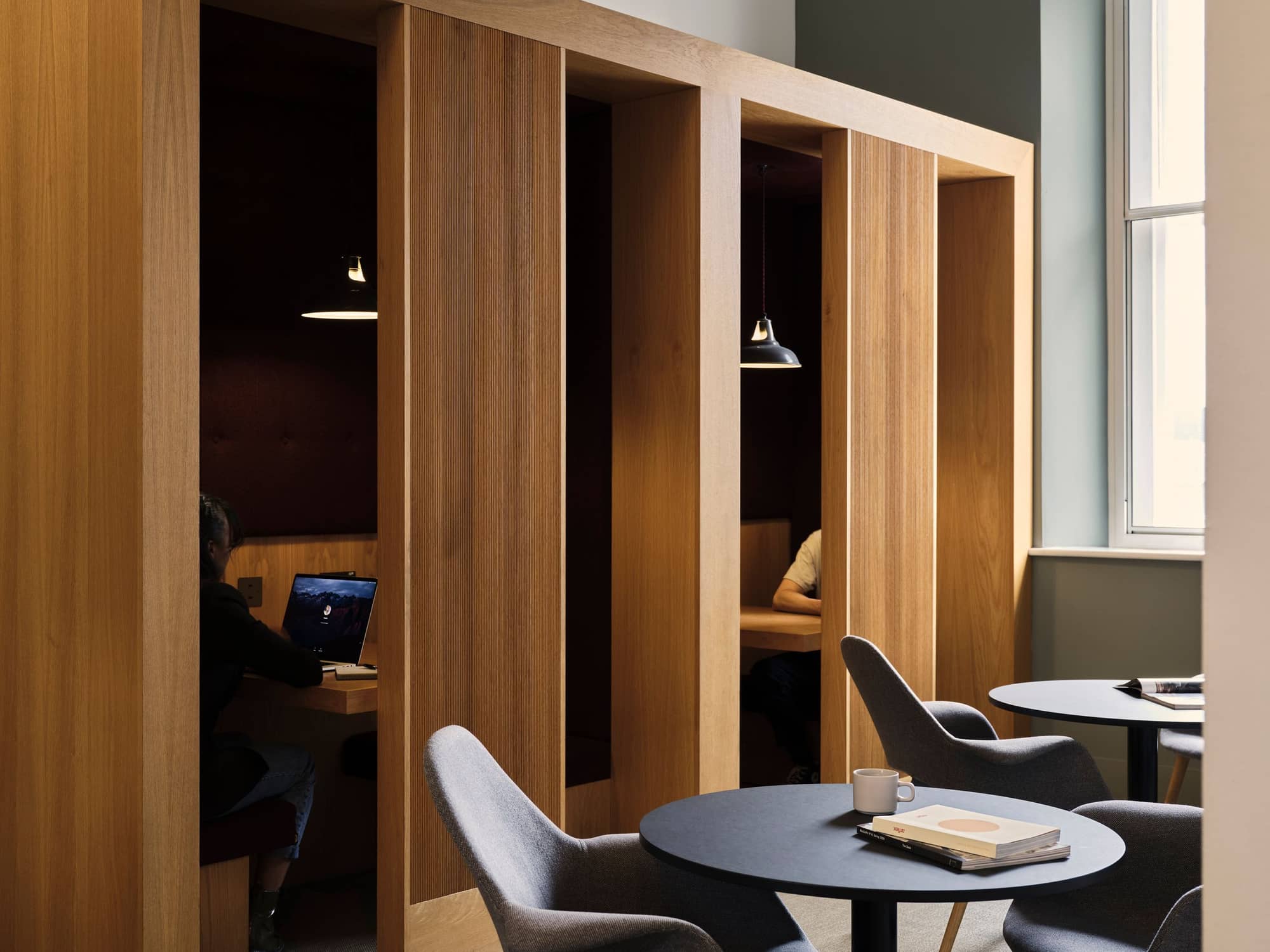 Two people working in private office cubicles at 19 Eastbourne Terrace.