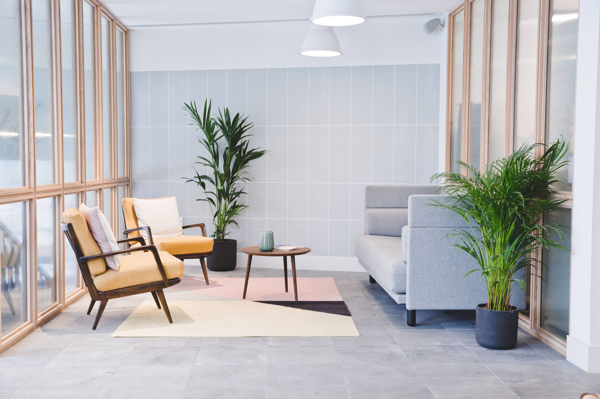 Bright seating area with large windows and a coffee table at Lloyds Avenue.