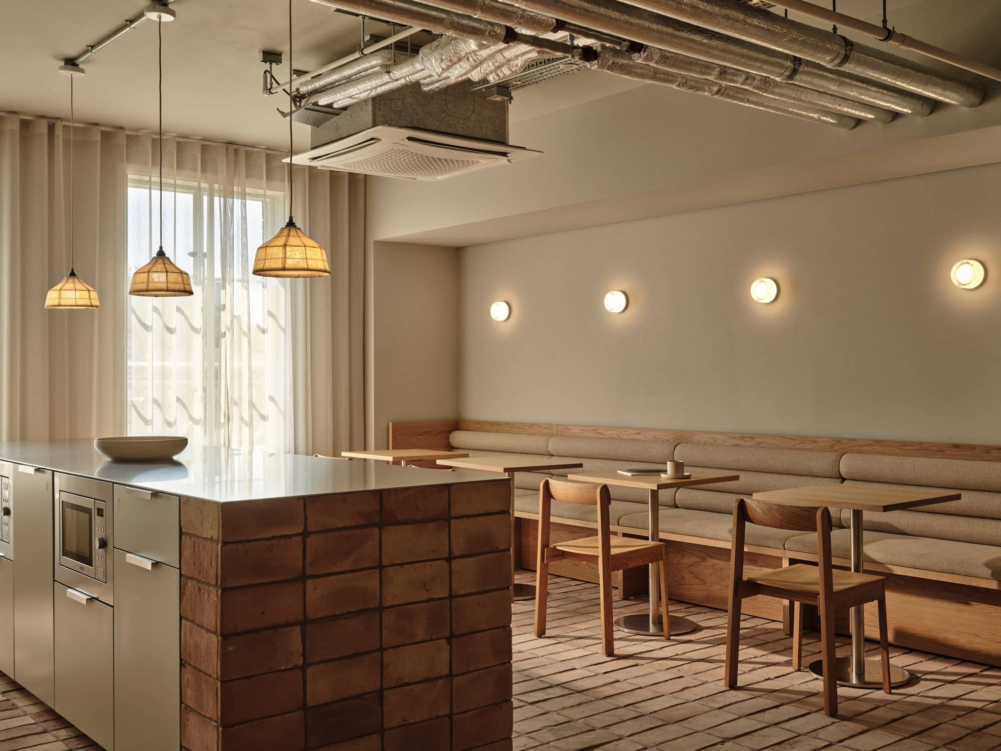 Minimalist kitchen and dining area with tables and benches at Chancery House.