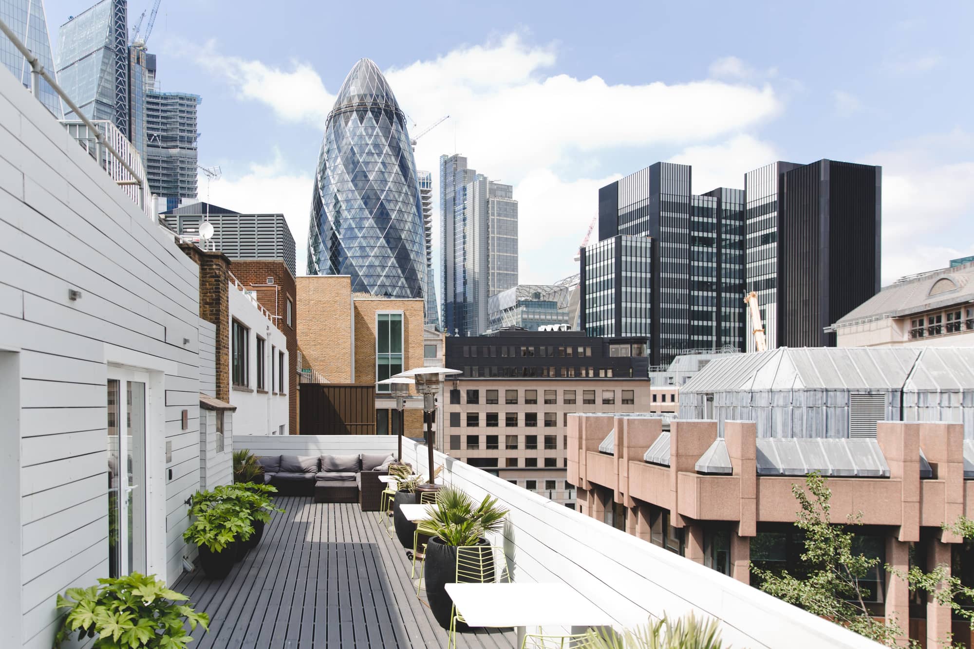 View of London's Gherkin Tower from a modern terrace with seating areas in Lloyds Avenue.