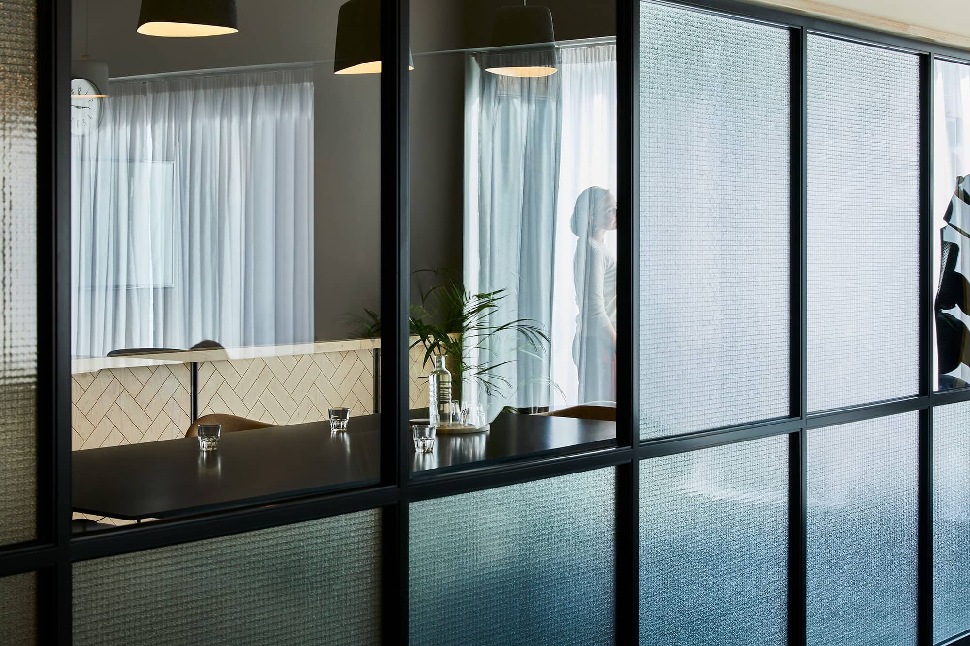 A modern meeting room with frosted glass walls, natural light and minimalistic décor.