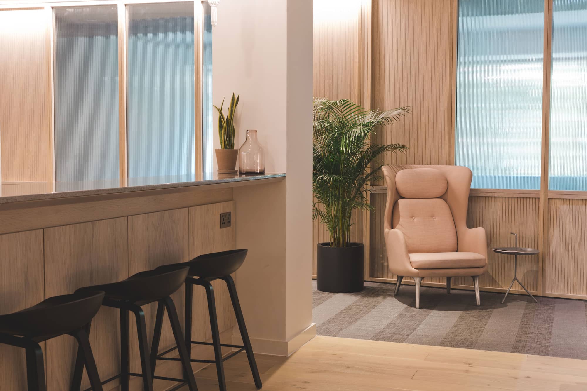 A workspace corner at 2 Stephen Street with a contemporary armchair and bar stools.