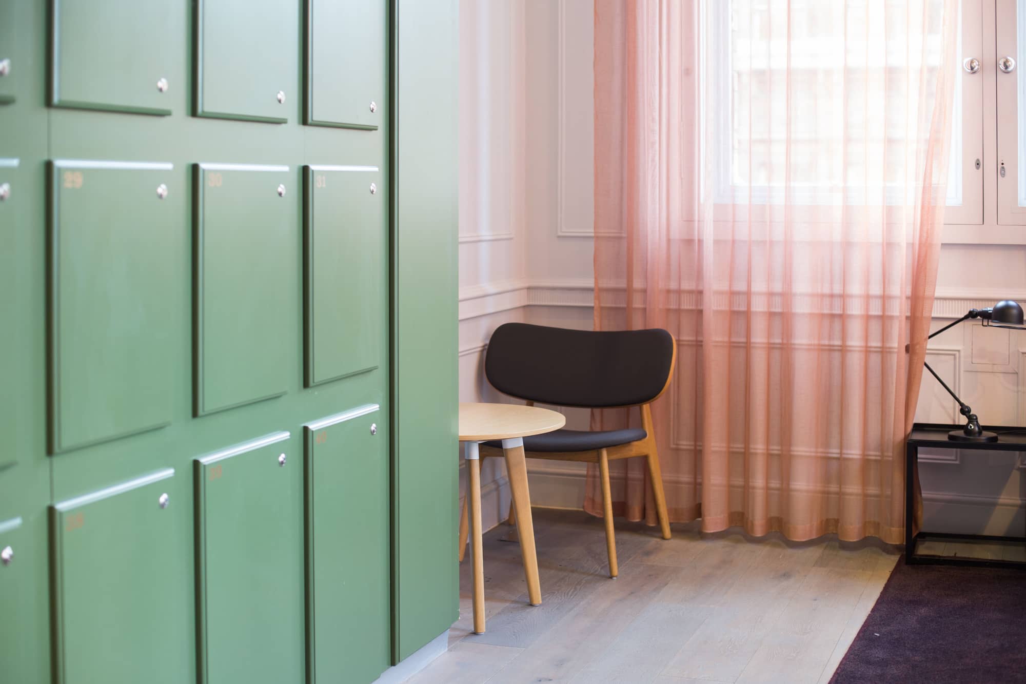 Modern space with table and chairs and lockers at 50 Liverpool Street.