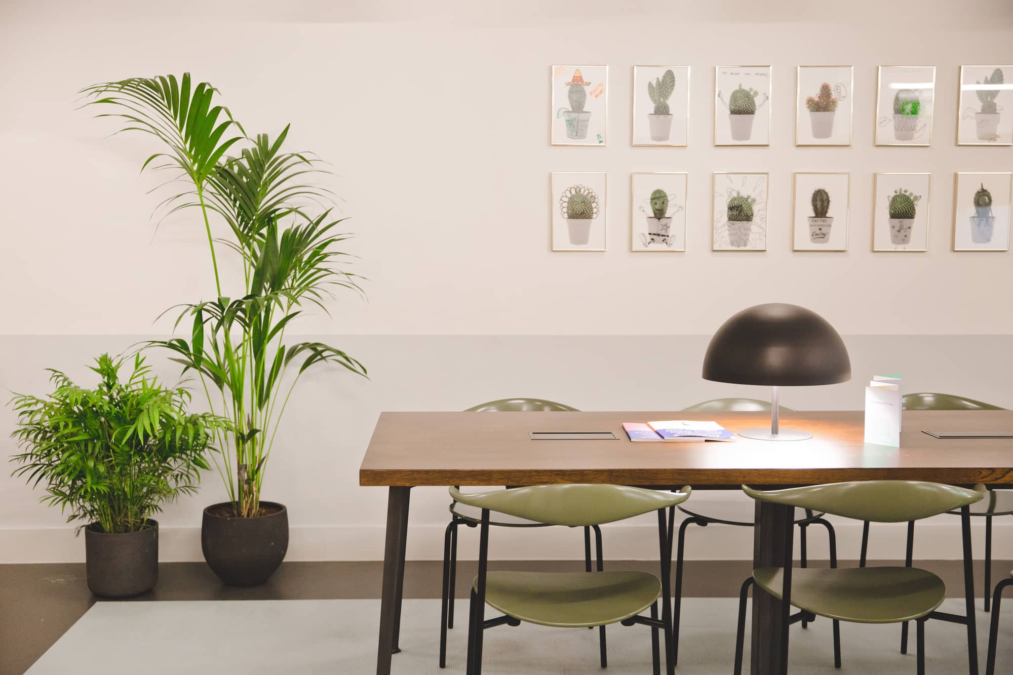 Modern mid-century meeting room table and chairs with modern wall art at Lloyds Avenue.